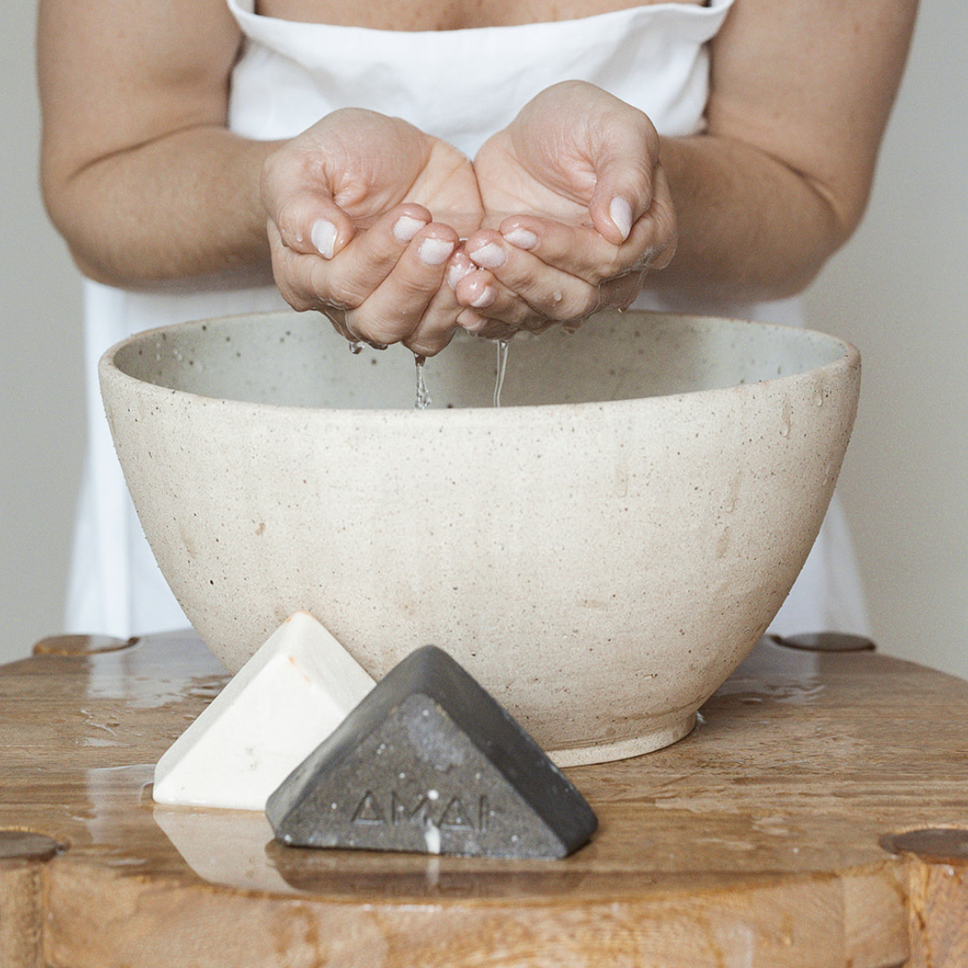 Hands with water and facial exfoliating bar soap