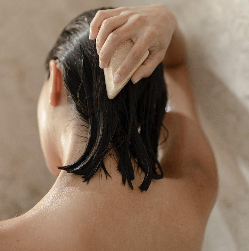 Woman washing her hair with natural shampoo bar
